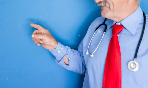 Portrait of a senior doctor on blue medical background