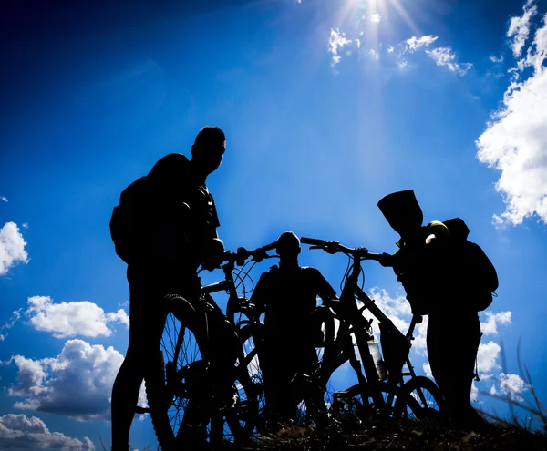 Biking group at sunset sky background.