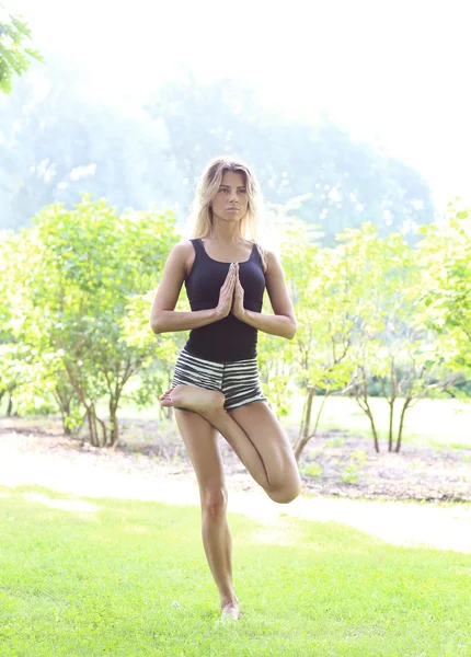 Beautiful woman practicing outdoor yoga