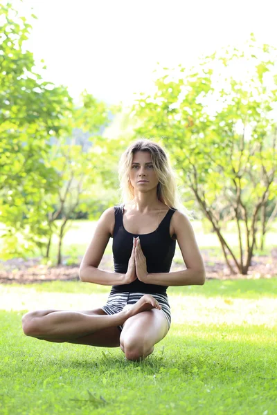 Beautiful woman practicing outdoor yoga