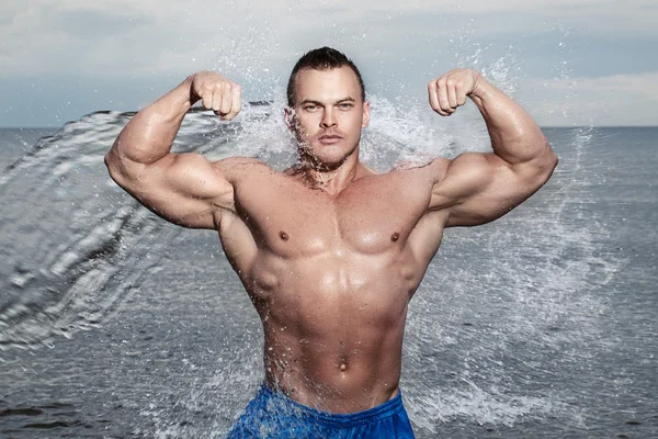 Bodybuilder with sexy body on the beach