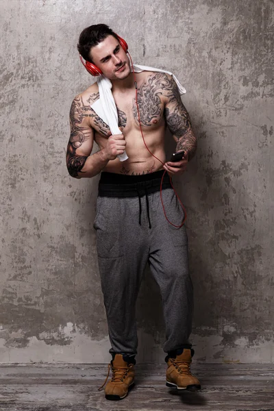 Tattooed man with red headset in sportwear