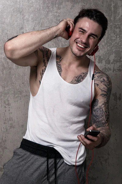 Tattooed man with red headset smiling
