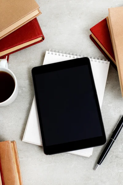 Books and tablet on table