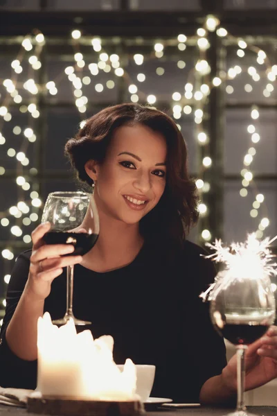 Woman with red wine and sparkler