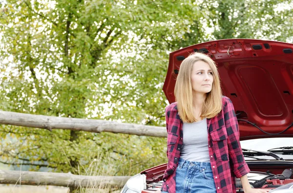 Young woman near broken car