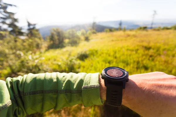 Hiker looking at electronic compass, travel and navigation