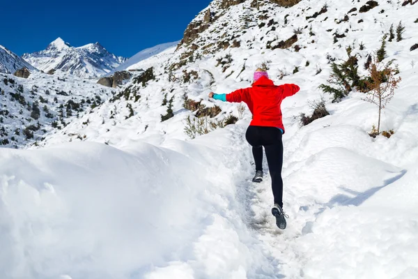 Woman jumping running in winter mountains