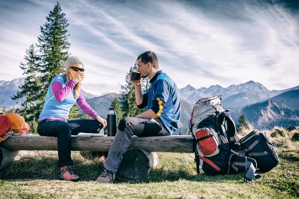 Couple hike and drink in mountains