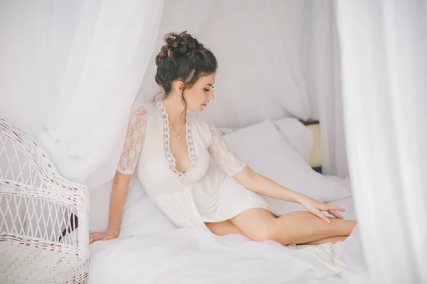 Beautiful brunette girl in white bedroom