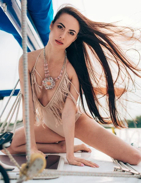 Woman in stylish swimsuit on yacht