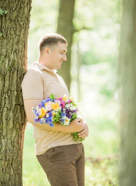 Young man with a bouquet of wild flowers