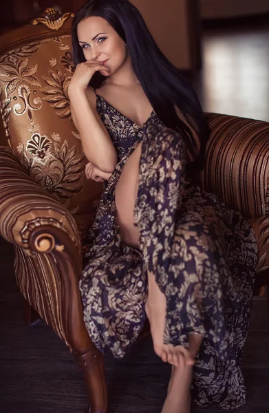 Beautiful woman is in an arm-chair