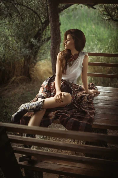 Woman in fashion clothes sitting outdoors