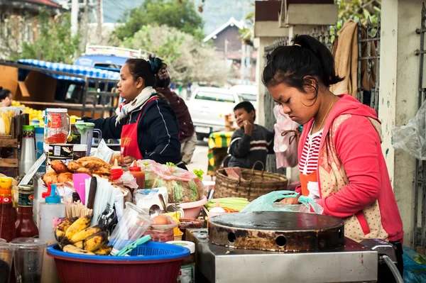 People selling food at asian market. Laos