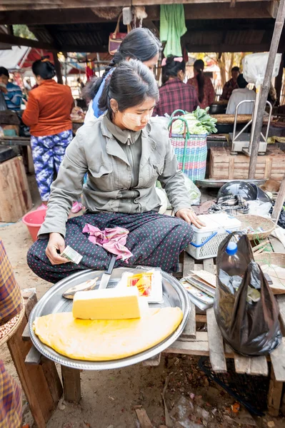 Asian woman selling tofu at marketplace