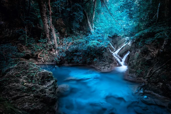 Mystery night at tropical forest with waterfall. Kanchanaburi, Thailand