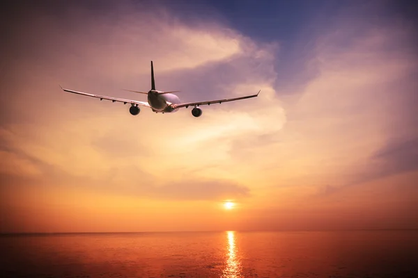 Airplane flying over amazing tropical ocean at sunset. Thailand travel