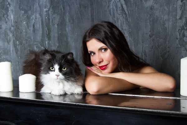 Girl with a cat at the piano