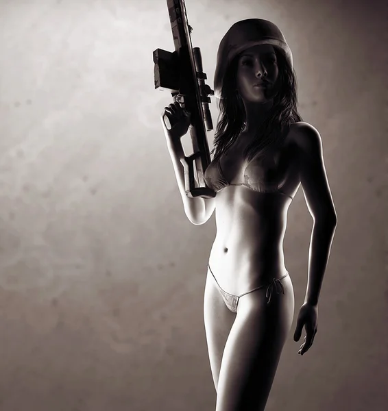 Beautiful sexy bikini woman holding army weapon