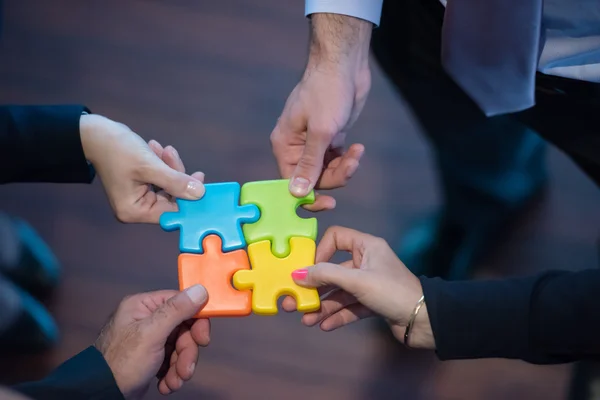 Top view of business people group assembling jigsaw puzzle