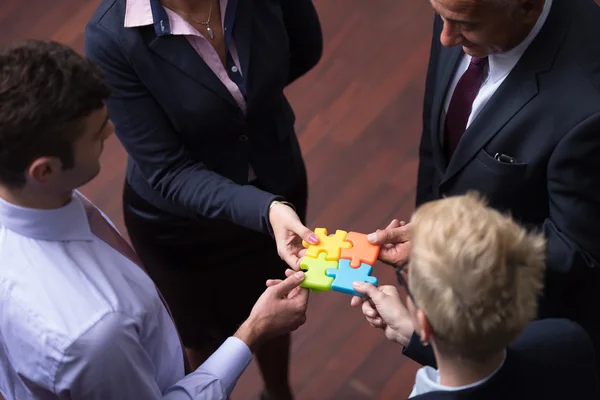 Top view of business people group assembling jigsaw puzzle