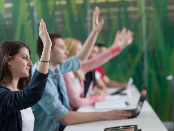 Students group raise hands up on class