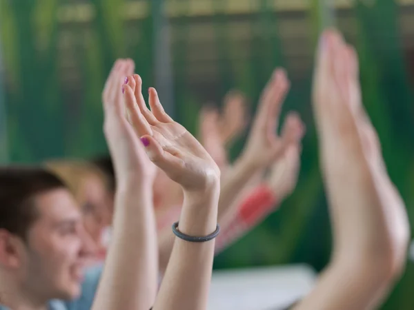 Students group raise hands up on class