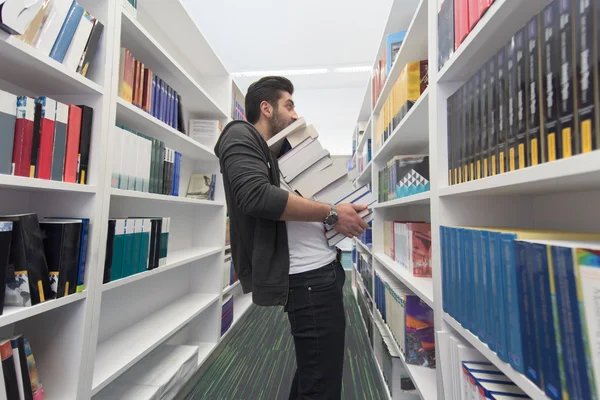 Student holding lot of books in school library