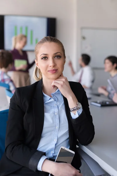 Portrait of young business woman at office with team on meeting