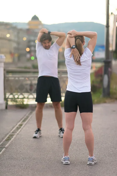 Couple warming up before jogging