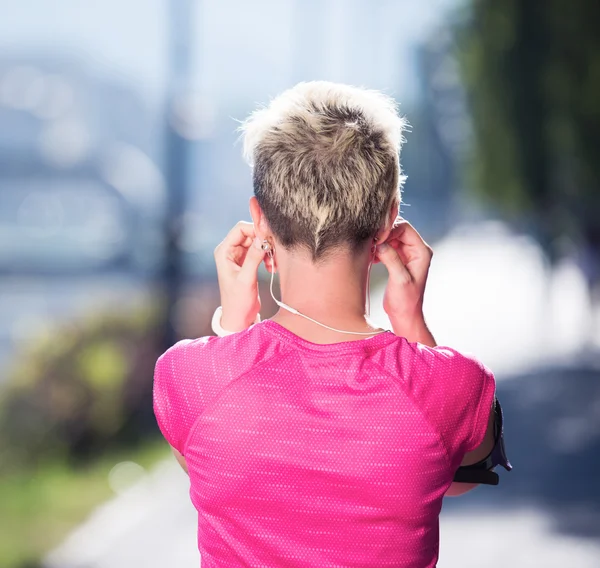 Jogging woman setting phone before jogging