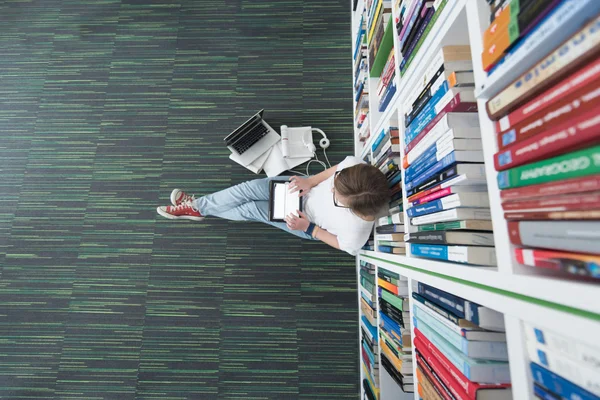 Female student study in library, using tablet and searching for