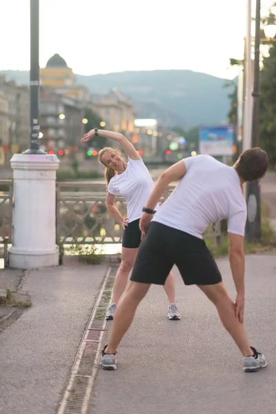 Couple warming up before jogging