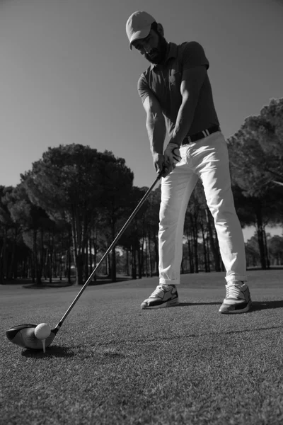 Golf player placing ball on tee