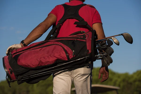 Close up of golfers back while   walking and carrying golf  bag