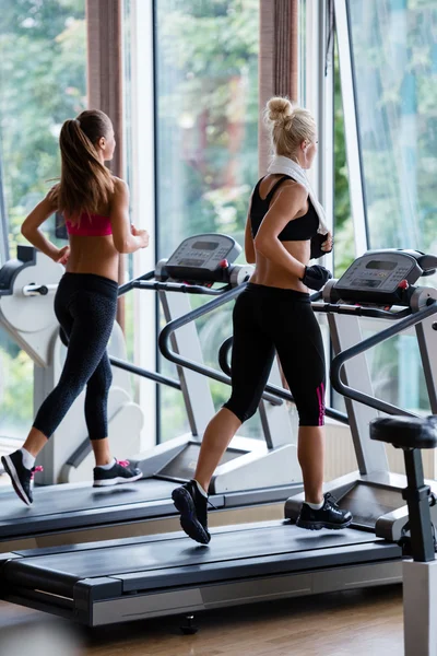 Friends exercising on a treadmill at gym