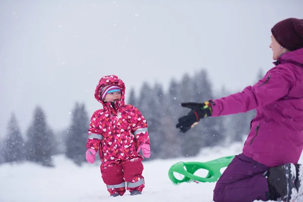 Mom and cute little girl have fun in winter