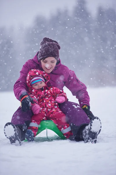 Mom and cute little girl have fun in winter