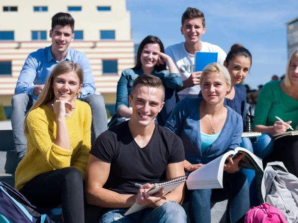 Students outside sitting on steps