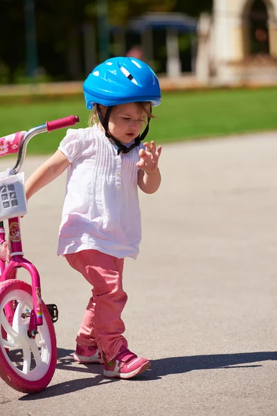 Girl in park learning to ride a bike