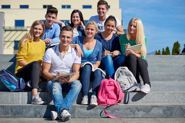 Students outside sitting on steps