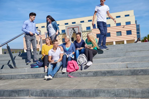 Students outside sitting on steps