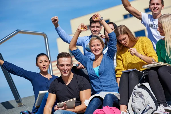 Students outside sitting on steps