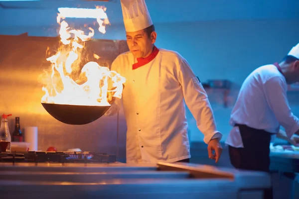 Chef preparing vegetables with fire