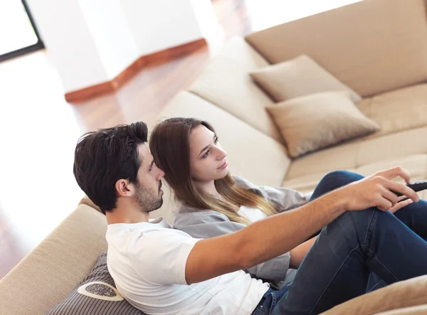 Young couple watching tv at home