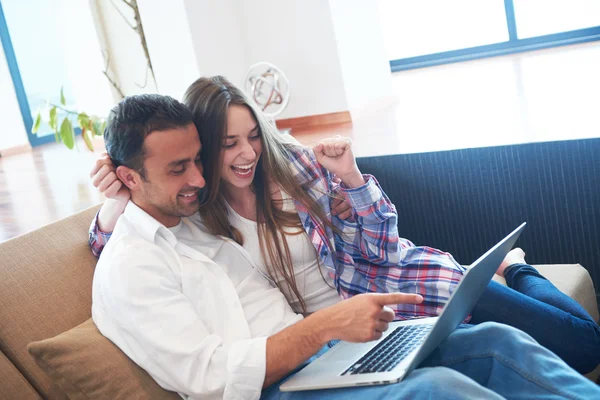 Relaxed young couple working on laptop computer