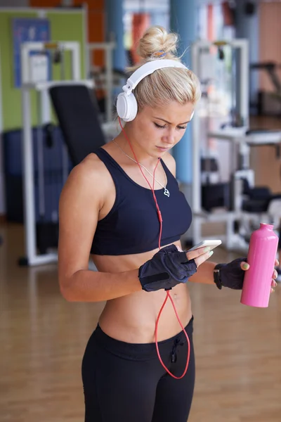 Woman with headphones in fitness gym