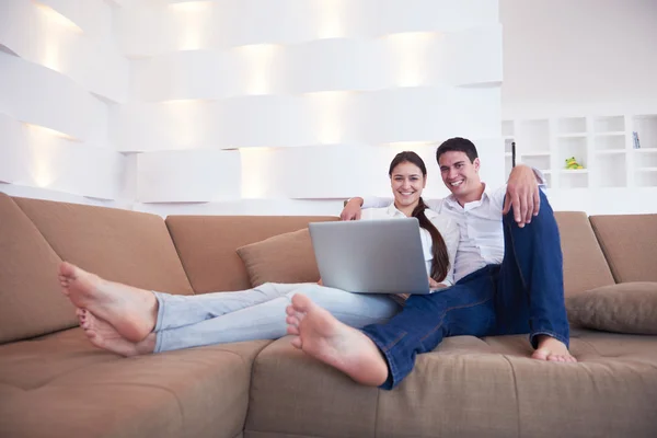Relaxed young couple working on laptop computer at home