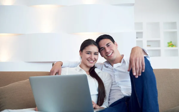 Relaxed young couple working on laptop computer at home